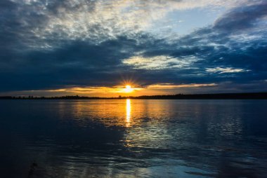 Sahilde yanan bulutlar ile gündoğumu deniz