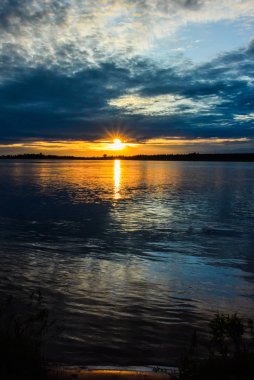 Sahilde yanan bulutlar ile gündoğumu deniz