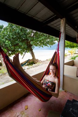 Genç Turizm Malezya tropikal Tioman adasında otel balkonda hamak üzerinde rahatlatıcı. Güney Doğu Asya Tekek sahilde güzel tesis.