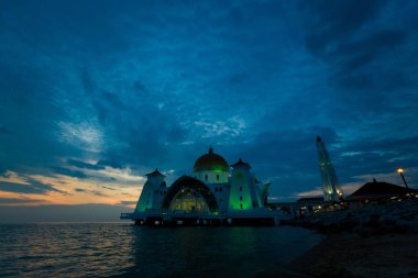 Beautiful architecture of Melaka Straits Mosque in Malacca city in Malaysia. Beautiful sacral building in south east Asia during sunset. clipart