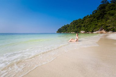 Young tourist relaxing in sea on secret beach on Pangkor island in Malaysia. Beautiful seascape and harbor taken in south east Asia. clipart