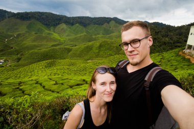 Landscape with couple of tourists on Bharat tea plantation in Cameron Highlands mountains in national park in Malaysia. Agriculture of south east Asia. clipart