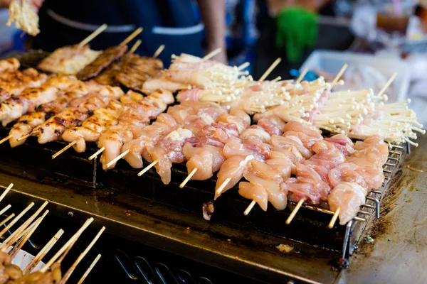 Fresh asian spicy needle mushroom and chicken skewers barbeque on local market. Traditional thai cuisine made of fresh ingredients.