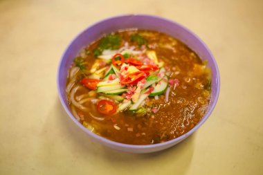 Penang Adası yerel restoranda taze hazırlanmış Malezya Penang Laksa baharatlı erişte çorbası servis. Geleneksel Asya mutfağı taze malzemelerle yapılmış.