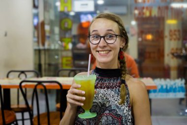 Langkawi Adası yerel restoranda buz çay içme genç turist. Geleneksel Asya mutfağı taze malzemelerle yapılmış.