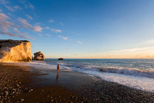 Genç kafkas kadın turist susnet sırasında taş sahilde güzel Afrodit Kayalıkları üzerinde. Kıbrıs Adası'nda alınan manzara.