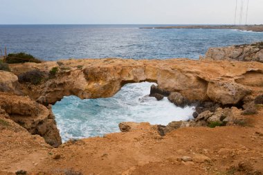 Bulutlu hava sırasında güzel Cape Greco Kamara Tou Koraka taş kemer. Kıbrıs Adası'nda alınan manzara.