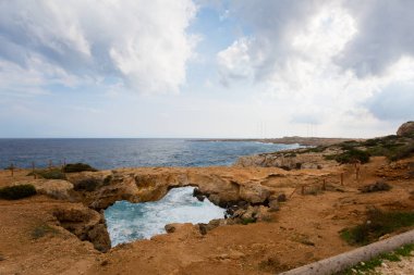 Bulutlu hava sırasında güzel Cape Greco Kamara Tou Koraka taş kemer. Kıbrıs Adası'nda alınan manzara.
