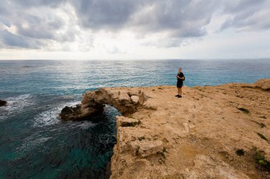 Turist güzel Cape Greco monachus kemer üzerinde köprüyü seviyorum. Kıbrıs Adası'nda alınan manzara.