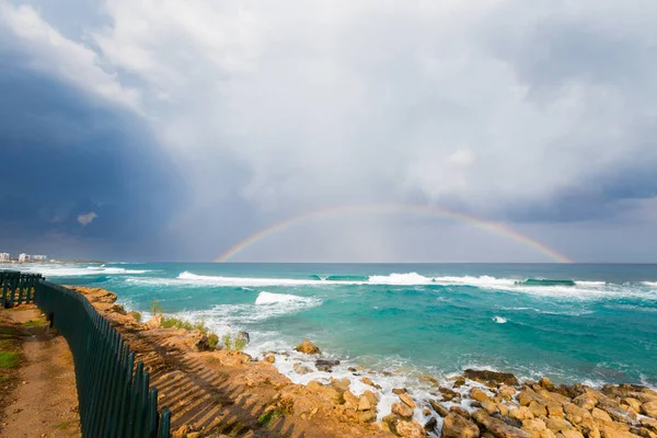 Beautiful Cape Greco Protaras fig beach coast full of rock during cloudy weather. Landscape with rainbow taken on Cyprus island.