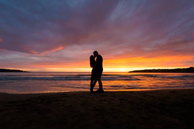 Genç Turizm silüeti birkaç güzel mercan defne üzerinde sırasında renkli susnet. Kıbrıs Adası'nda alınan manzara.