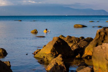 Vietnam 'ın Bai Thom bölgesindeki tropikal Phu Quoc adasında çalışan balıkçılar. Mavi gökyüzü ile Hon Mot - Kamboçya manzaralı manzara