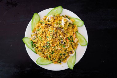 Kızarmış pirinci deniz ürünleriyle karıştırın: karides, kalamar, ahtapot, havuç, yumurta, taze soğan, balık. Geleneksel Vietnam mutfağı Phu Quoc, Vietnam 'daki liman restoranında servis edilir..