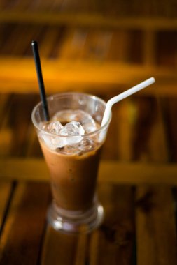 Tahta bir masada pipetle bir bardak vejetaryen Vietnam kahvesi. Fotoğraf Mui Ne 'de çekildi..