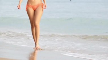 Denizde oynayan bikini giyen bir kadın.