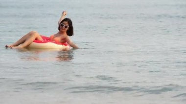 Denizde oynayan bikini giyen bir kadın.