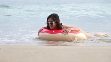 Denizde oynayan bikini giyen bir kadın.