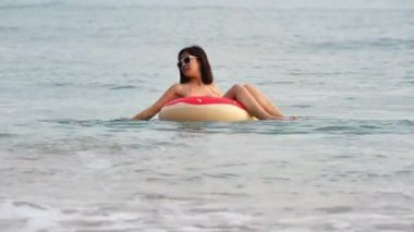 Denizde oynayan bikini giyen bir kadın.