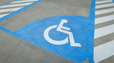 Yol yüzeyinde tekerlekli sandalye simgesi engelli erişimi için ayrılmış bir şeridi simgeliyor, dahil edilmeyi, ulaşılabilirliği, güvenliği ve kentsel ulaşım tasarımında eşitliği simgeliyor.