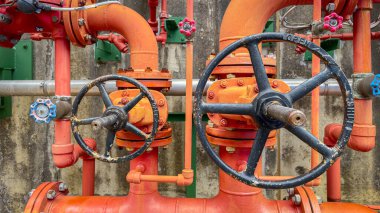 Renkli yangın söndürme boruları ve kontrol ekipmanları, güvenlik, yangın önleme, işlevsellik ve yönetmeliklere uymayı sembolize eden endüstriyel bir fabrikaya kurulmuştur..