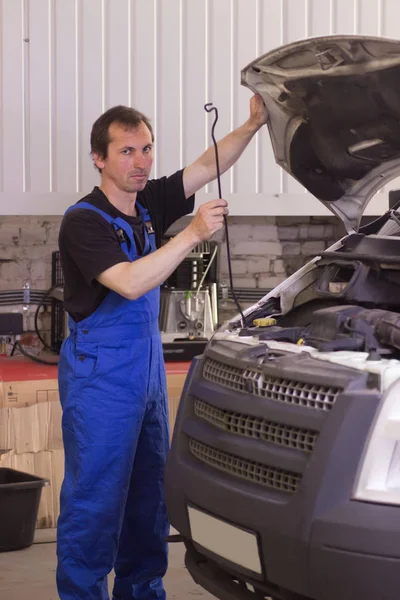 Technician working in the auto service and repairing a car