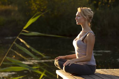Mutlu kadın doğada Yoga uygulamak