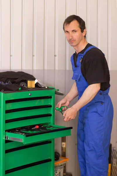 Technician holding auto repair tools in the garage