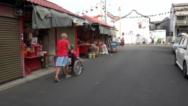 Una mujer empuja silla de ruedas — Vídeos de Stock