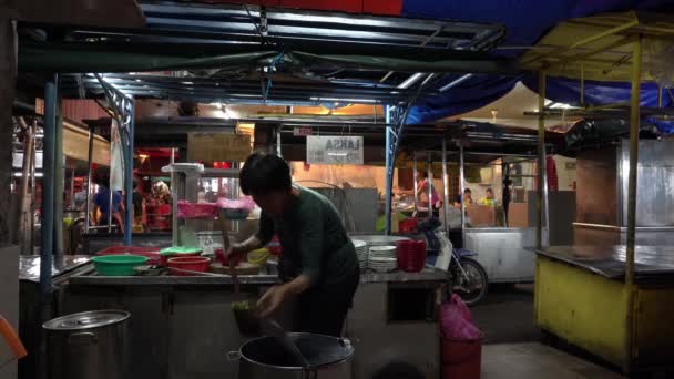 Продавец Лаксы готовит еду в ларьке на аллее Пек Гонг Ченг. . — стоковое видео