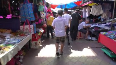 İnsanlar sabah pazarında yürürler.