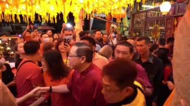 Maliye Bakanı, zenginlik tanrısı ziyaretçiyle tokalaşıyor.