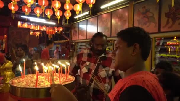 Indiska anhängare bränner rökelse pinne vid kinesiska templet på Chew Jetty. — Stockvideo