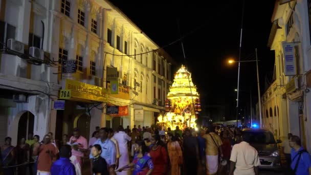 Een auto trekt aan de gouden wagen in de stad tijdens Thaipusam. — Stockvideo