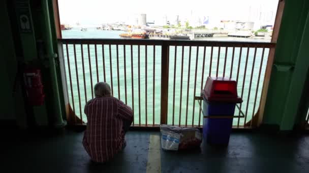 Starý muž sedí u trajektu a dívá se na scenérii — Stock video