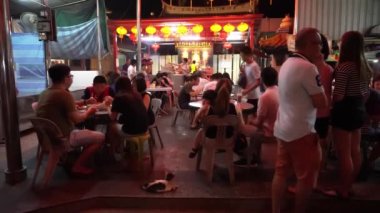 İnsanlar tapınağın önünde yemek yiyor..