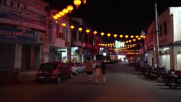 Une famille se promène dans la rue décorée de lanterne rouge. — Video