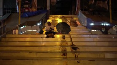 Merdivenlerde bir adam oturuyor.