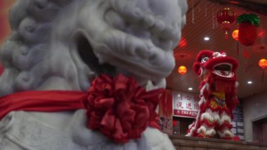 Aslan, aslan heykelinin yanında dans eder.