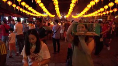 Kuş, Çin Yeni Yılı boyunca Çin tapınağındaki bir dindar tarafından kafesinden salınır..