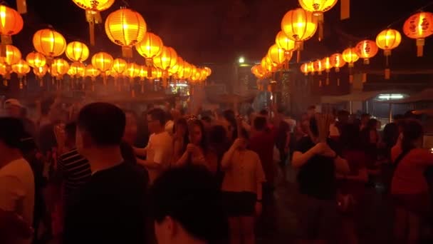 Panning crowds pray at temple. — Stock video