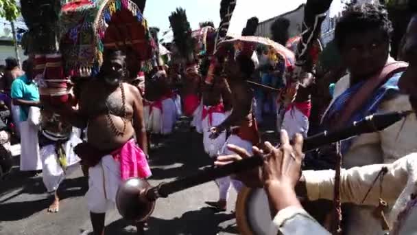 Indiai bhakták dobolnak, trombitálnak és kavadi hordozó táncot járnak az utcán. — Stock videók