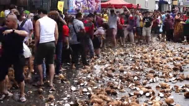 Chinois briser les noix de coco à la rue pendant Thaipusam. — Video