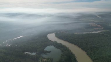Bir sürü ağacı ve gölü olan bir nehir. Su kahverengidir. Gökyüzü bulutlu. Hava görüntüsü Kota Tinggi, Johor