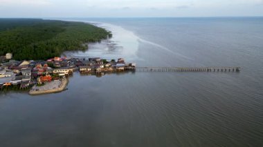 Büyük bir su kütlesinin kıyısında küçük bir kasaba bulunmaktadır. Kasaba evler ve binalarla çevrilidir. Segenting 'in hava manzarası, Batu Pahat.