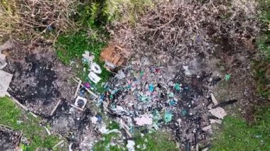 Yerde bir çöp yığını var. Toprağın ortasında bir yığın çöp var.