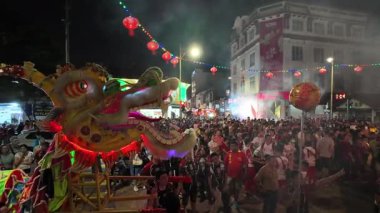 George Town, Penang, Malezya - 24 Şubat 2024: Yüzlerce insan, Poh Hock Seah Büyük Geçit Töreni sırasında ejderha ritmik dansından büyülenerek yol kenarında toplandı