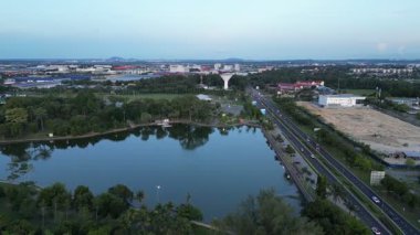 Pasir Gudang, Johor, Malezya - 29 Nisan 2024: Yoğun yolun yanında bir göl