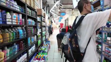 China Town, Singapore - Jul 17 2024: A man is shopping in a store aisle. There are bottles on the shelves at People's Park Centre