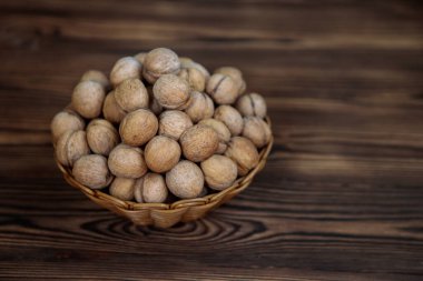 Ahşap bir arka planda içi ceviz dolu bir sepet. Doğal, sağlıklı ürün. Metin için boşluk.