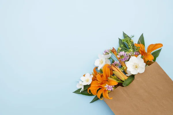 Mavi Arka Planda Işi Çantasındaki Bir Buket Çiçek Çiçek Teslimatı - Stok İmaj